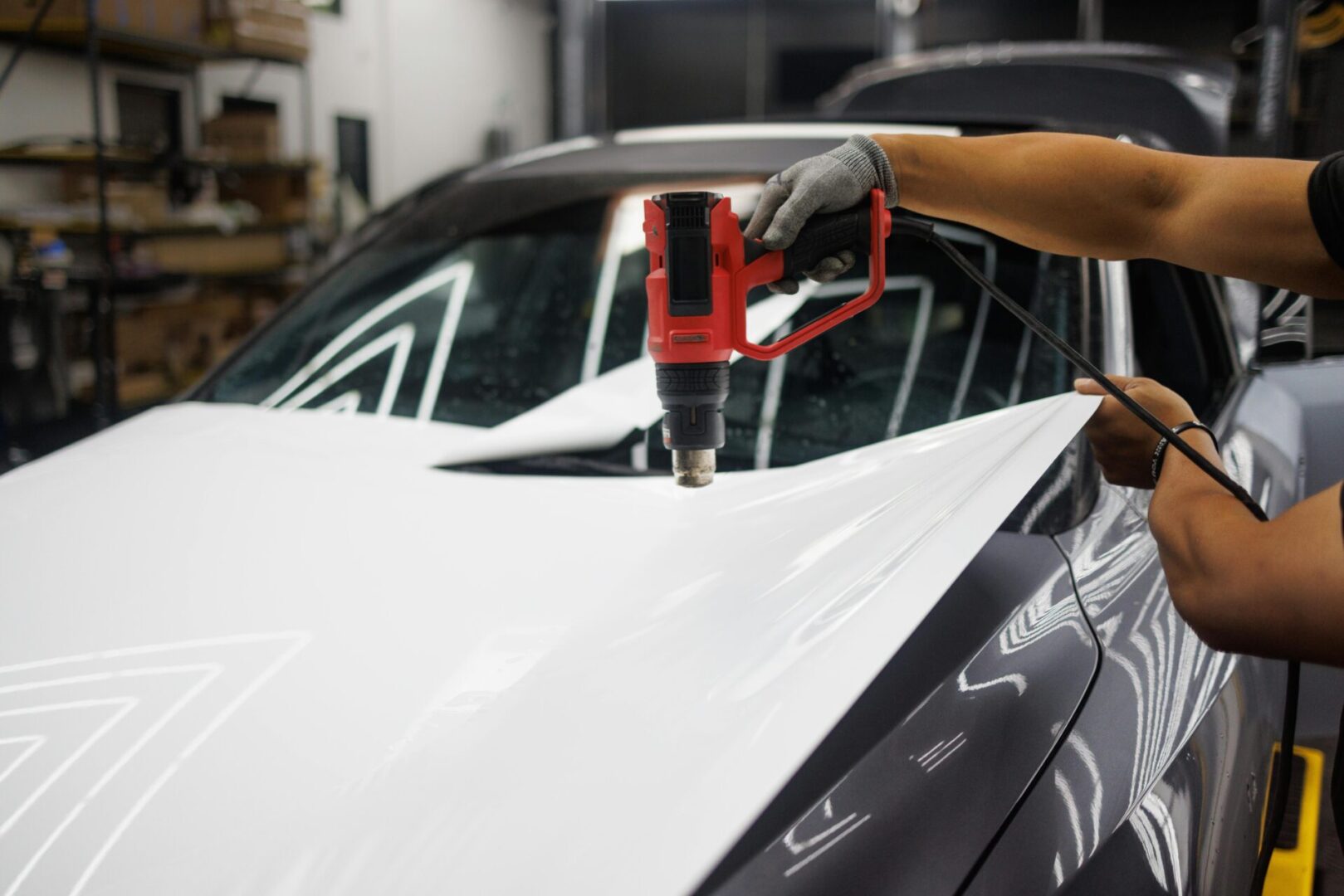 A person using a drill to fix the windshield of a car.