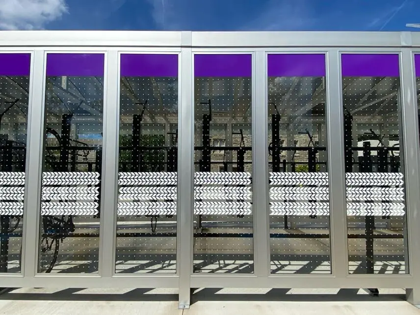 A bench sitting in front of a building with purple walls.