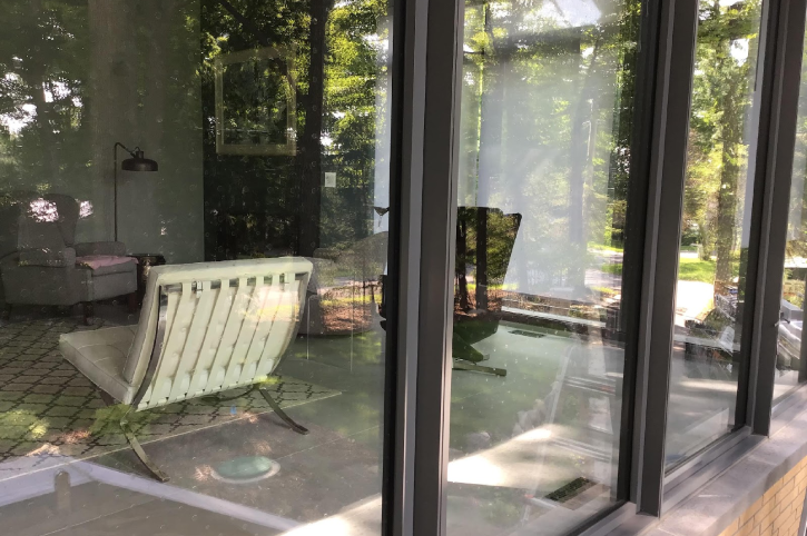 A patio door with a chair and table in it.